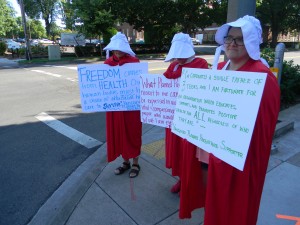 Protesters outside of Congresswoman Jaime Herrera Beutler's office don't want to become actual handmaids. 
