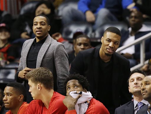 Portland Trail Blazers' C.J. McCollum, left, and Damian Lillard watch from the bench during the first quarter of an NBA basketball game against the Atlanta Hawks Monday, Dec. 21, 2015, in Atlanta. Leading scorers Lillard and McCollum sat out for Monday night's game due to injuries. Lillard has plantar fasciitis in his left foot. McCollum has two sprained ankles. (AP Photo/David Goldman)