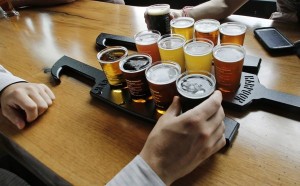 A couple taste a selection of 12 different beer flights at the Beer Hall at the Harpoon Brewery in Boston. (photo by  Charles Krupa, Associated Press)