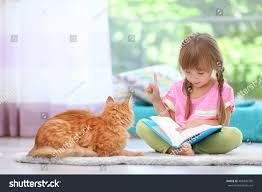 Little girl reading to cat