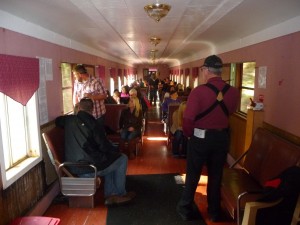Passengers stretching out on the Chelatchie Prairie Railroad Wine Train as volunteer points out photo ops along the line