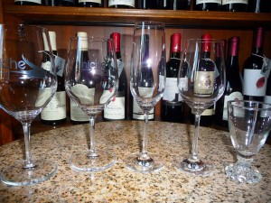 From left to right: 16 ounce red wine glass, 14 ounce white wine glass, Champagne flute, spirits wine glass with tulip shape to release aromas of Scotch for example, fun fortified wine glass for things like Port and Sherry. 