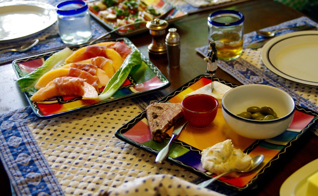 Food from top, clockwise: Caprese salad; plate with Frommage de Affinois, salty green olives, Tuscan bean spread and pate; melon with proscuitto. 